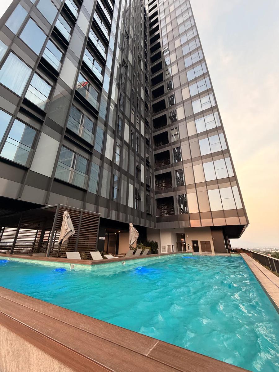 Alberca con vista a torre residencial, amenidad edificio Santa Fe CDMX