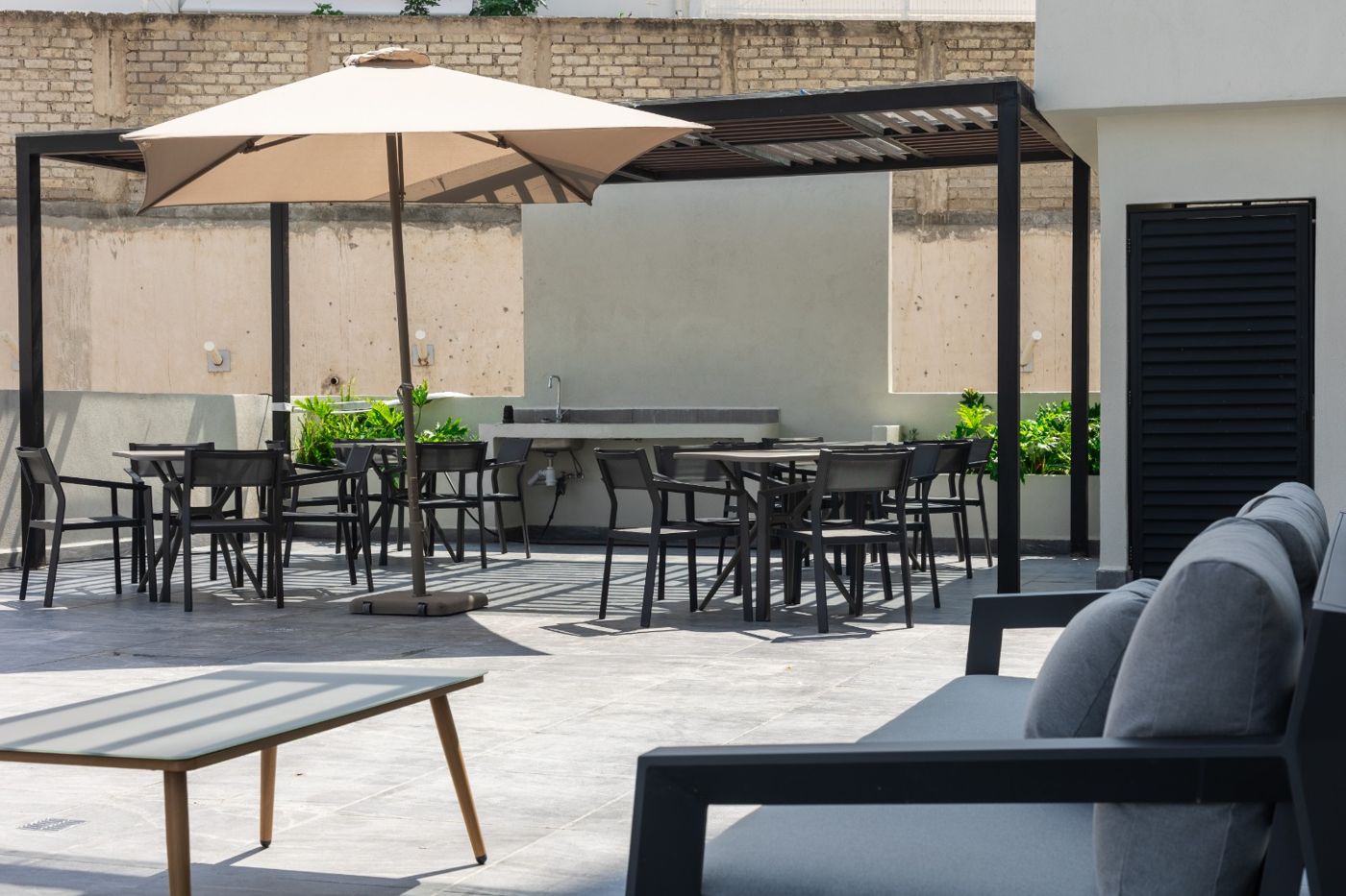 Terraza con asadores y mesas del desarrollo en Capital Norte
